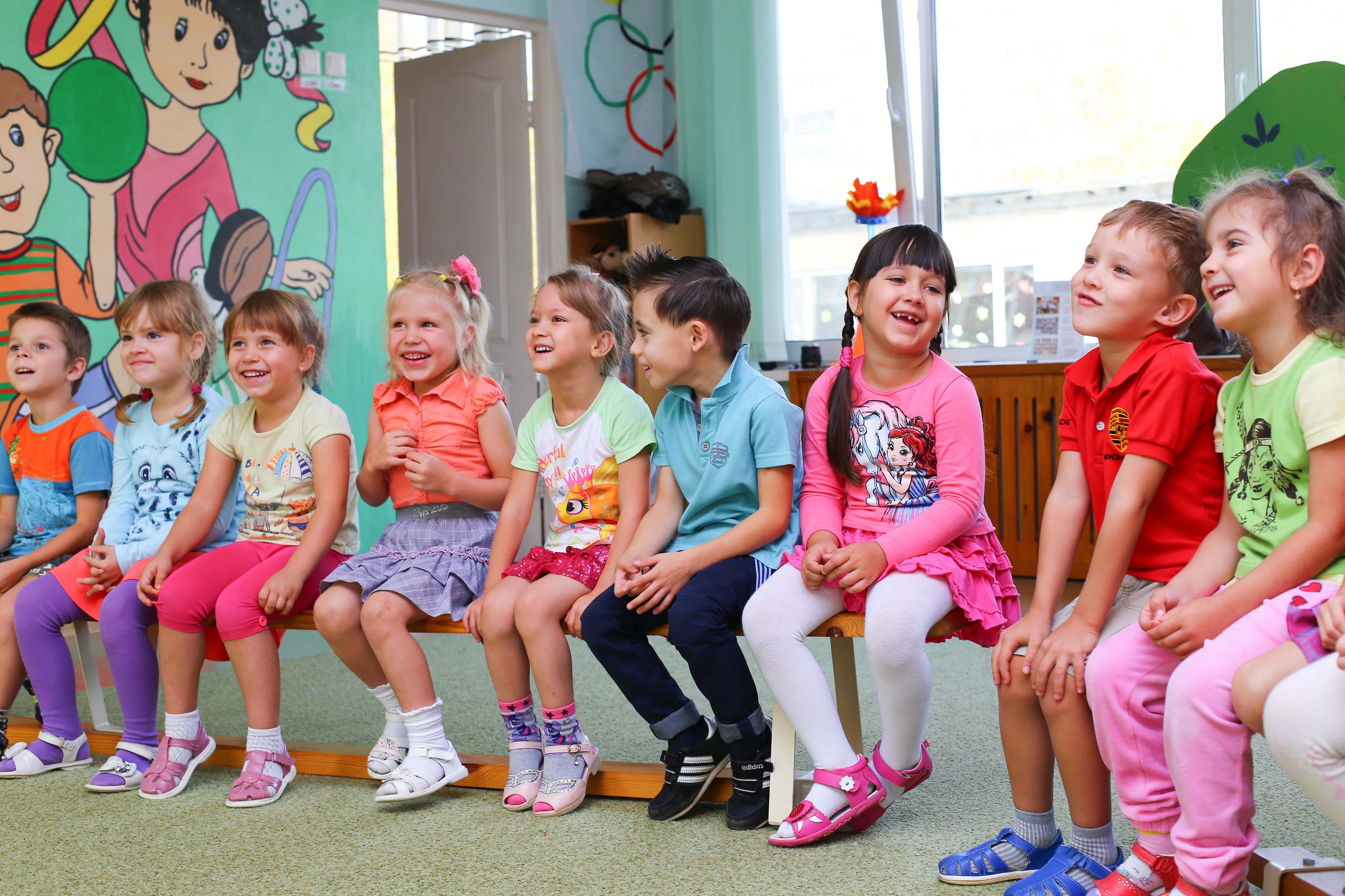 Kinder basteln gemeinsam in einem hellen Kita-Raum